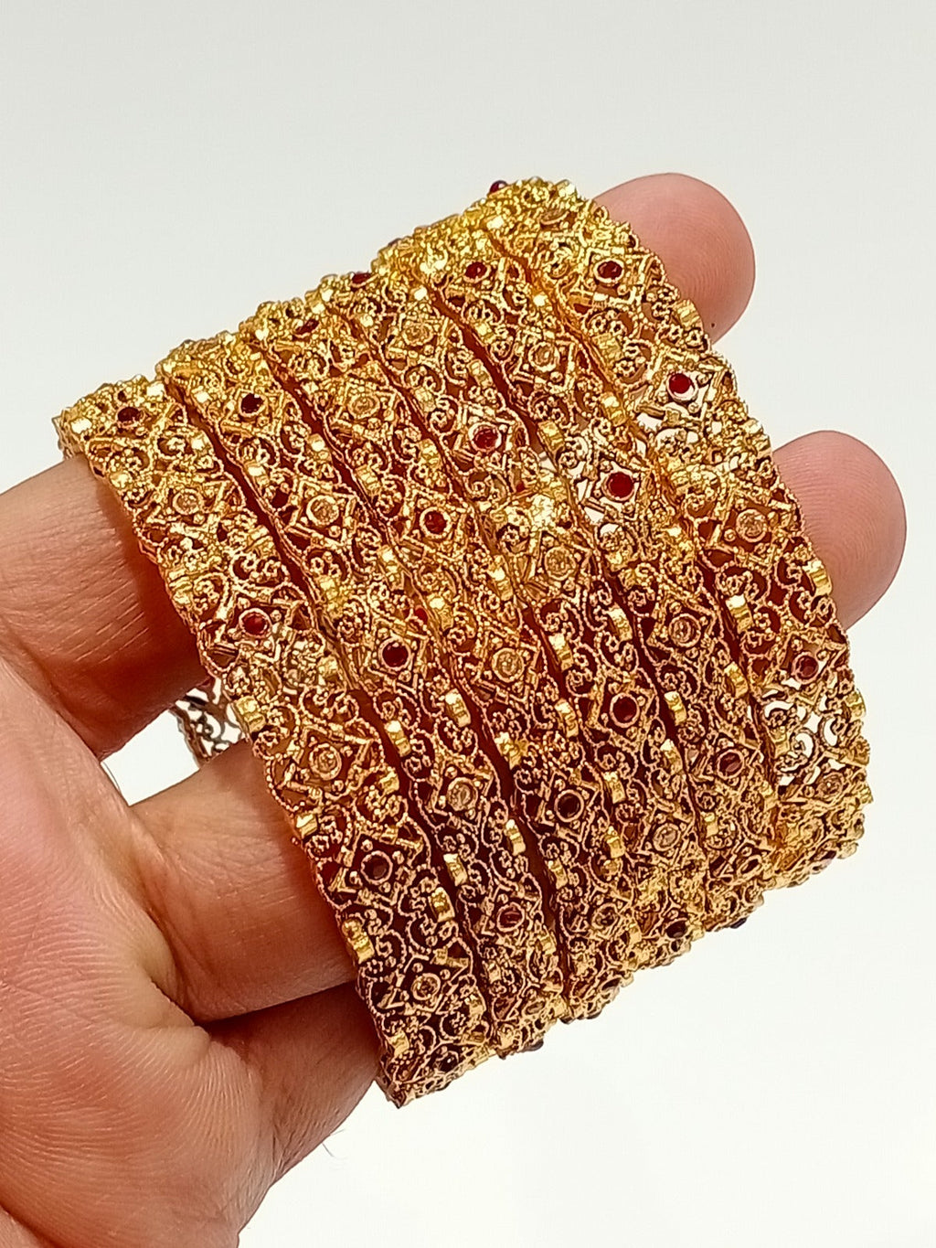 Gold filigree bridal bangles with ruby stones - hand held view
