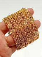 Gold filigree bridal bangles with ruby stones - hand held view