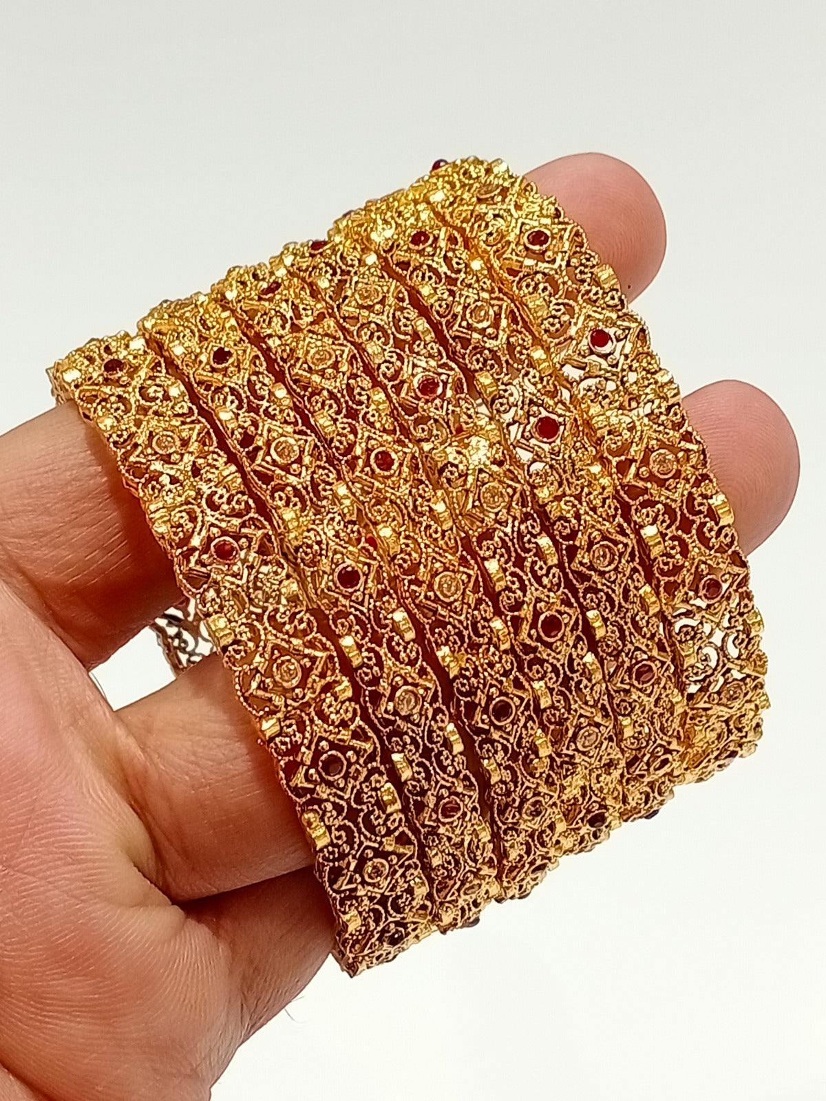 Gold filigree bridal bangles with ruby stones - hand held view